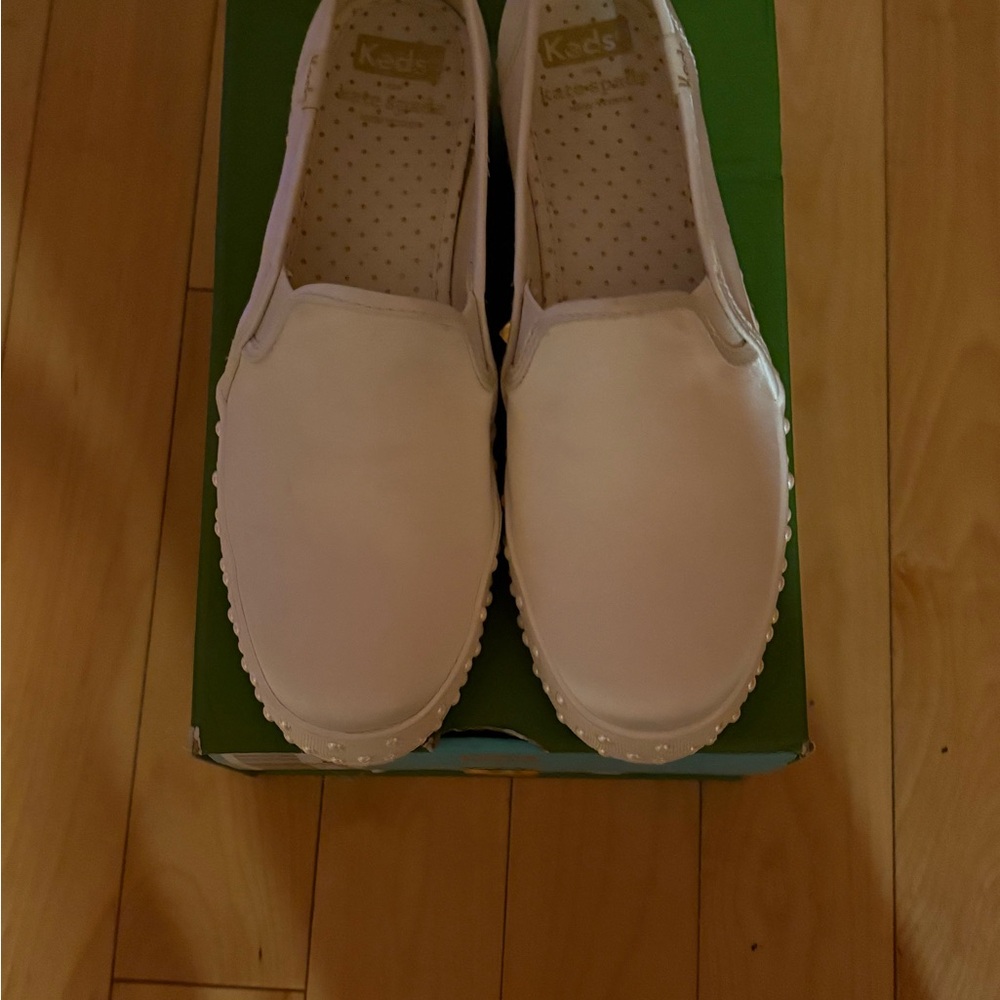 Keds Women's Classic White Slip-On Kate Spade Sneakers with pearls on the sole.